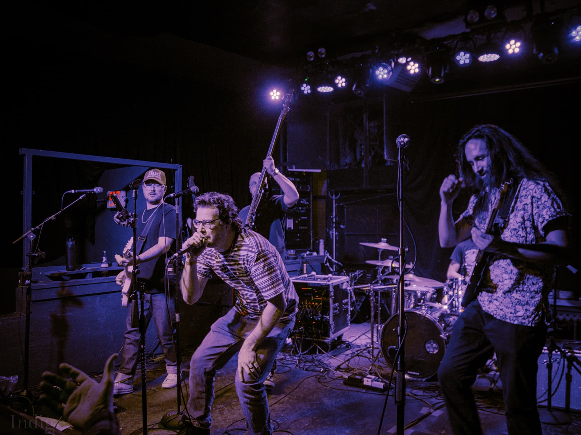 Full band on stage with blue lighting