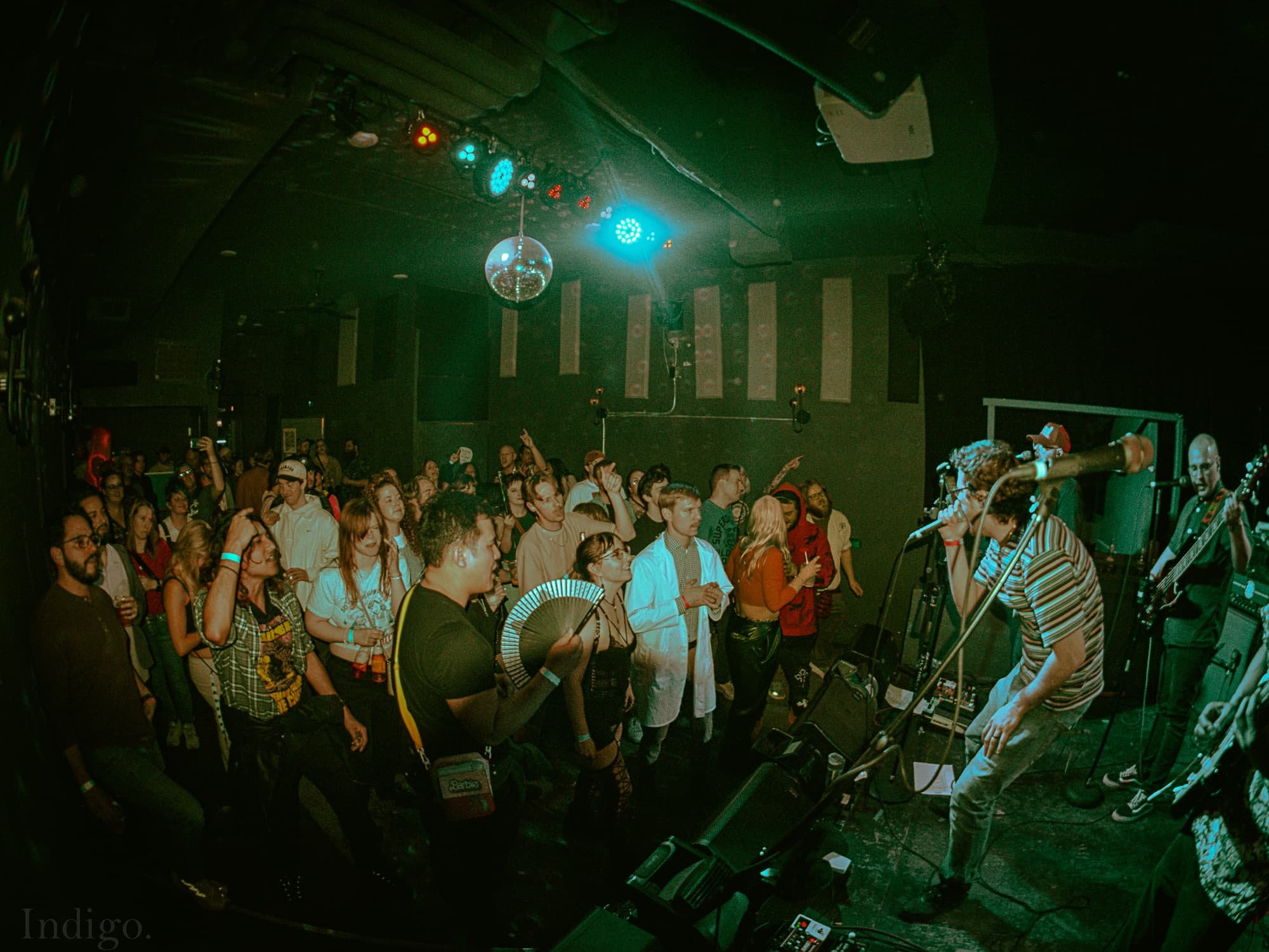 Crowd dancing with green stage lights