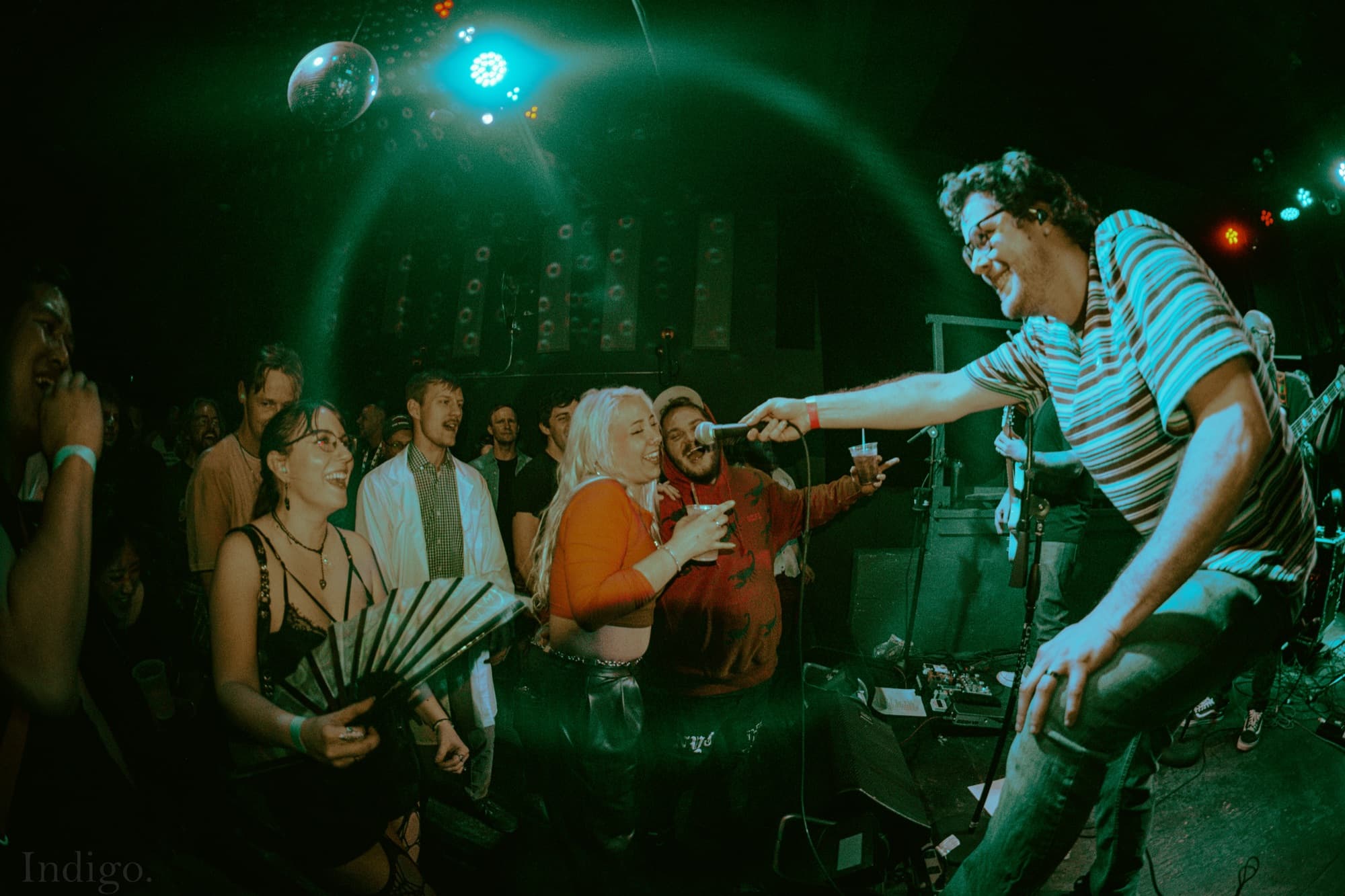 Vocalist sharing mic with fan in crowd