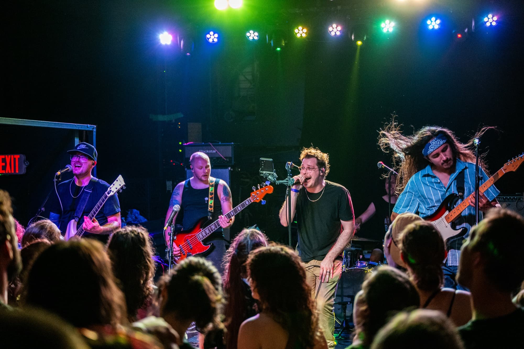 Full band performing under colorful lights